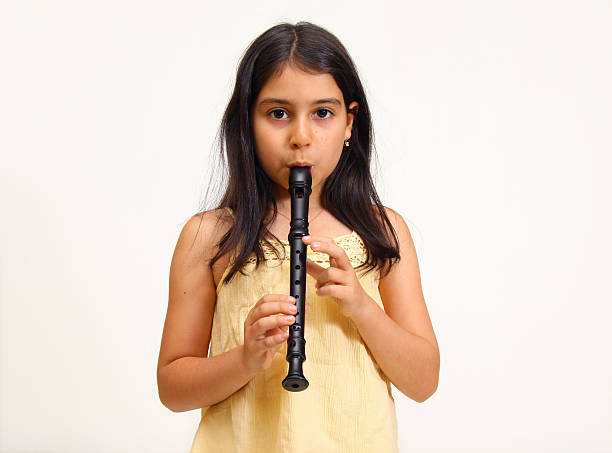 Young girl playing recorder stock photo