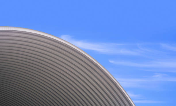 padrão da curva do telhado de aço ondulado grande contra o fundo azul do céu - architecture roof aluminum sheet industry - fotografias e filmes do acervo