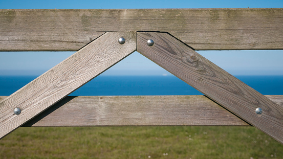 Wooden gate in field by the sea