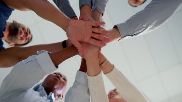 Business people, hands and together with team and support, collaboration and team building low angle. Business meeting, connection with trust, community and solidarity with teamwork and motivation