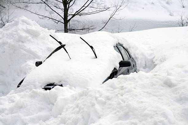 Car buried under large snowdrift stock photo