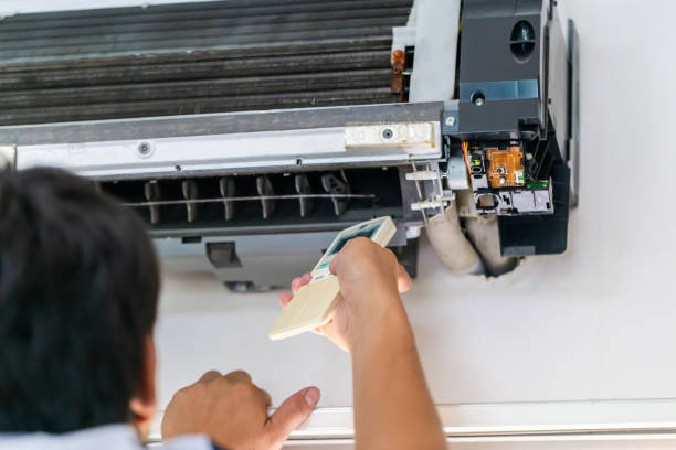 istock Technician man turn on air conditioner with remote control, Male technician fixing and cleaning modern air conditioner indoors, Maintenance and repairing concepts 1468795832