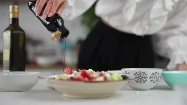 Young Caucasian Woman Pouring Some Balsamic Vinegar Over A Plate Served With A Fresh And Colorful Salad