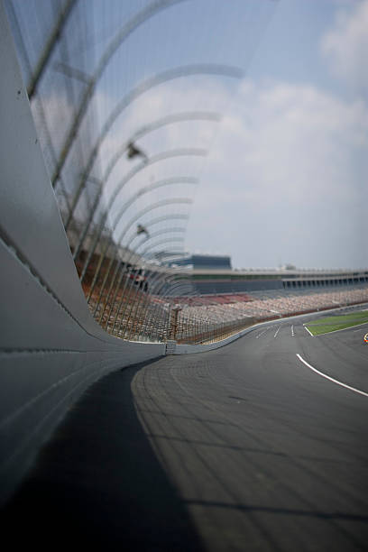 Stock car race track. A low angle shot of a race track, shot from the safer barrier wall looking into turn one. Focus is shifted, shot with a Canon Mark 2 1Ds. stock car stock pictures, royalty-free photos & images