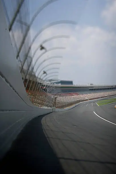 A low angle shot of a race track, shot from the safer barrier wall looking into turn one. Focus is shifted, shot with a Canon Mark 2 1Ds.