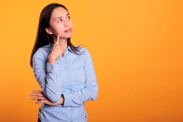 istock Doubtful asian woman thinking with finger on chin 1468799992