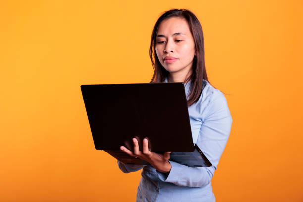 istock Filipino woman using laptop computer in front of camera 1468800351