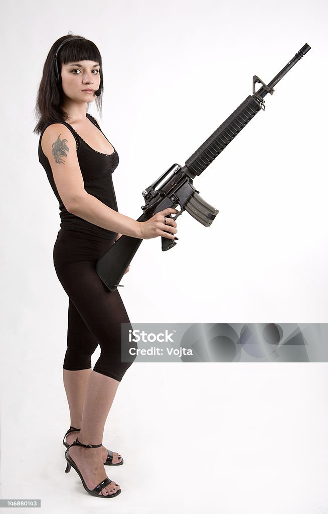 Chica con arma y auriculares. - Foto de stock de Adulto libre de derechos