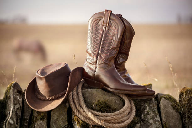Cowboy hat and boots at ranch stables, country music festival live concert or line dancing concept stock photo