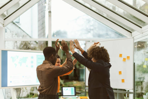 Group Startup Celebrates Success - High-Five Exchange in Office After Successful Brainstorming Session