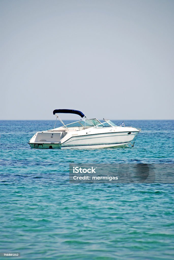 Motorboat in light blue aegean sea Motorboat anchored in the aegean sea, nearby the coastline of Skiathos. Aegean Sea Stock Photo