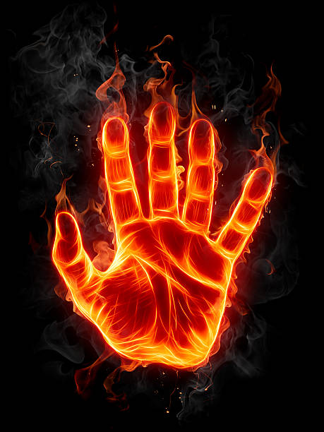 Fire hand burning against a black background stock photo