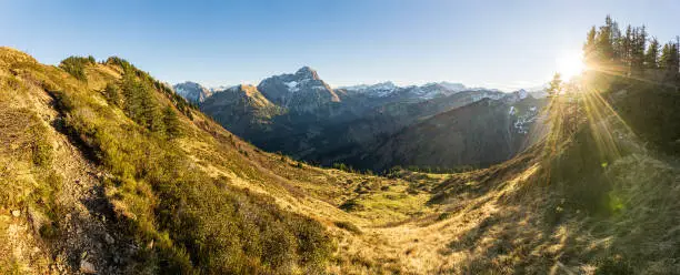 Great sunset in the mountains. Backlight with nice vibrant lens flares and sunbeams. Alps, Bavaria, Kleinwalsertal, Tirol, Austria.