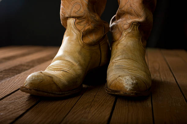 Cowboy boots on wooden floor stock photo