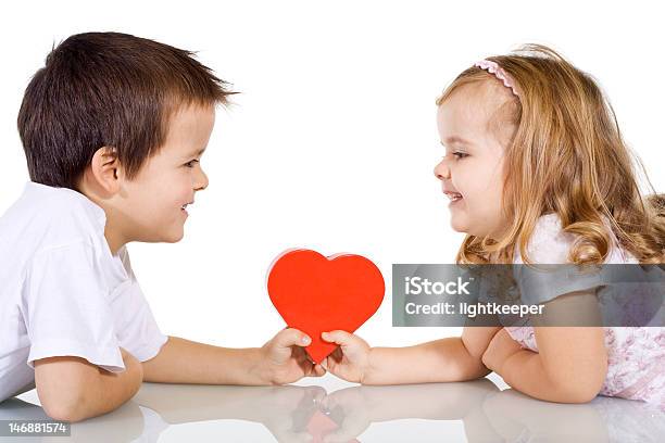 A Young Boy And Girl Holding A Love Heart Evenly On A Table Stock Photo - Download Image Now