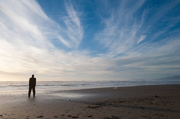 istock Man Standing by the Shore at Sunset 146881649