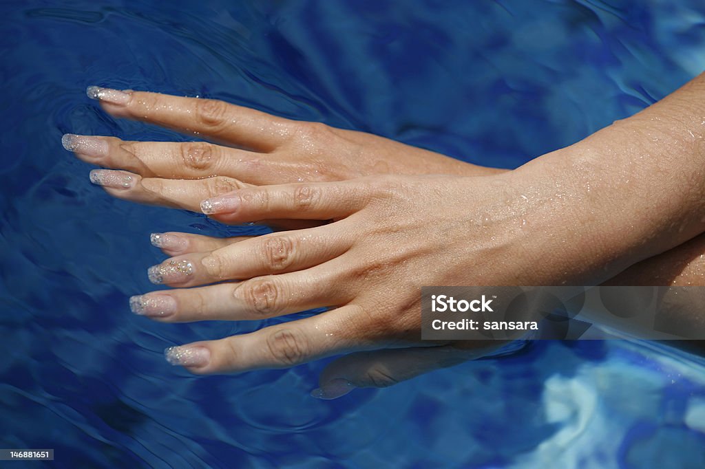 Hermosas mujeres manos en el blue water - Foto de stock de Adulto libre de derechos