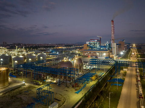 Illuminated petrochemical industry factory by a river at night