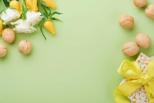 過越の祭りのコンセプト。マッツァ、コーシャ赤ワイン、クルミ、春の白と黄色のバラの花。明るい緑の背景に伝統的な儀式のユダヤ教のパン。過越の祭りの食べ物。ペサッハユダヤ教の祝� - matzo soup passover judaism ストックフォトと画像
