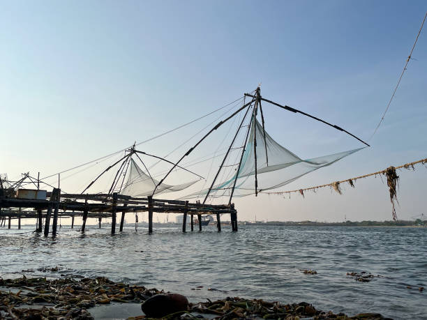 Chinese fishing nets in Fort Kochi Fishermen working with traditional Chinese fishing nets in Fort Kochi, Cochin, Kerala cochin kerala india chinese fishing net stock pictures, royalty-free photos & images