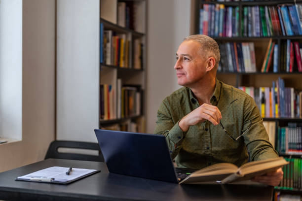 istock University mature professor in library looking away. 1468830005