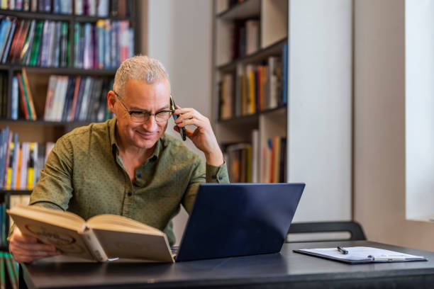 istock Male professor using mobile phone in the office 1468830519