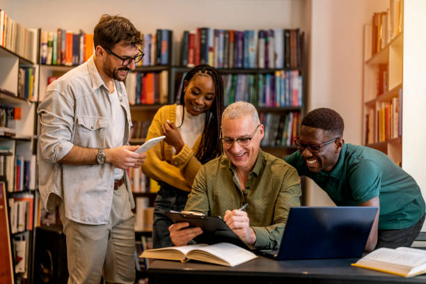istock Happy mature teacher assisting his students 1468830637