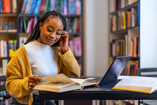 Young beautiful african american woman studying at home