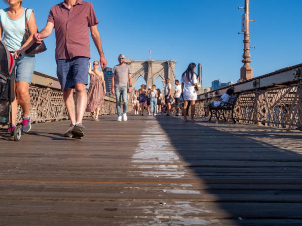 Pedestrians using the boardwalk of the Brooklyn bridge stock photo