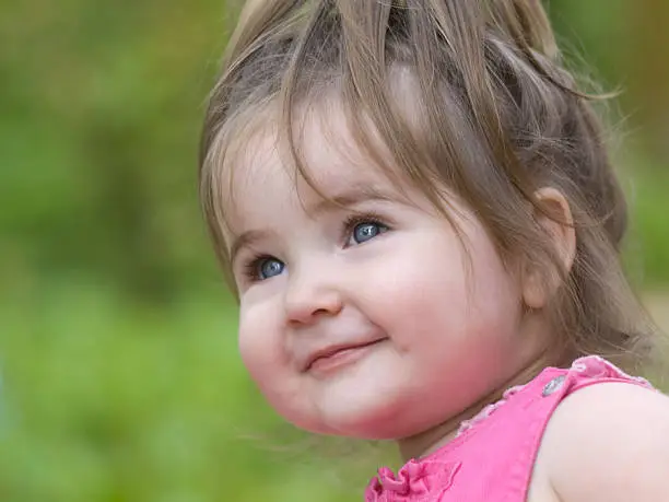 Nice little girl happily smiling and looking up.