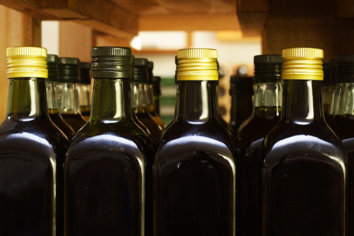 Bottles with olive oil in little private wine-cellar