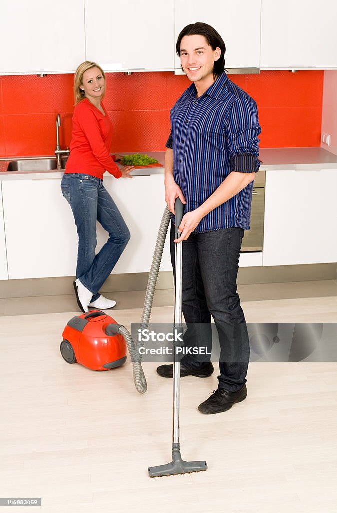 Человек vacuuming, женщина на фоне - Стоковые фото Близость роялти-фри