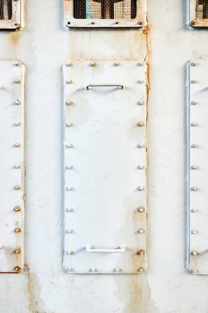 Three metal hatches plates on compressor for revision close-up with oil stains painted with gray paint bolted with studs and nuts background with copyspace.