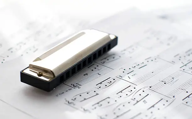 harmonica on sheets with blues notes lit by sunlight