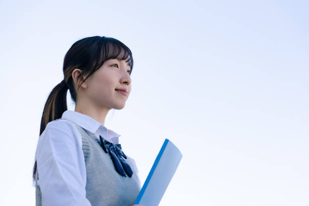 A high school girl in uniform looking far outside