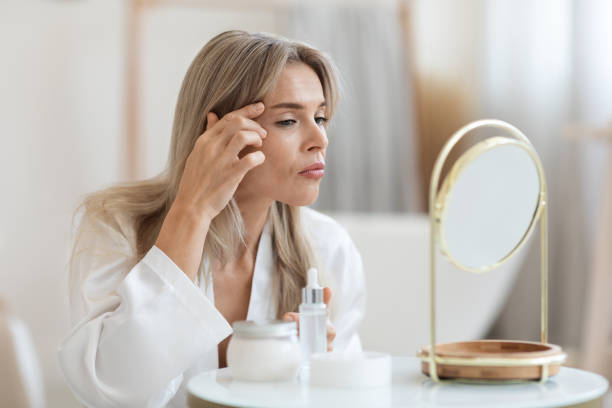 istock Middle aged woman checking her face in front of mirror 1468843104