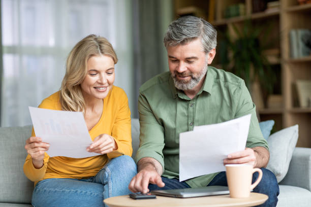 istock Middle aged spouses checking financial documentation while planning family budget at home 1468844184