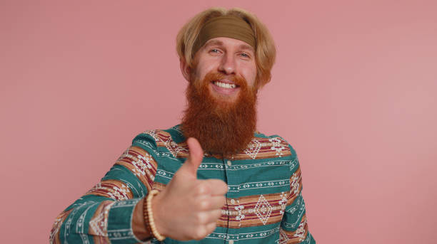 istock Bearded man raises thumbs up agrees or gives positive reply recommends advertisement likes good 1468844568