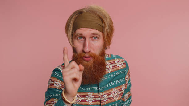 istock Hippie redhead man shakes finger and saying no, be careful, avoid danger mistake, disapproval sign 1468844574