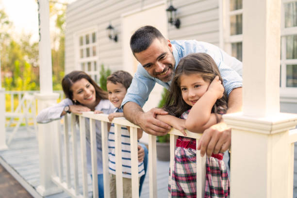 une jeune famille appuyée sur le perron avant - front stoop photos et images de collection