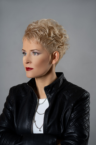 Studio shot of a beautiful serious woman with short blond styled hair and professional make-up