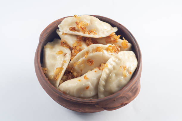 Boiled dumplings seasoned with spices in a plate on a white background. stock photo