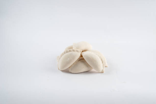 Raw fresh dumplings with meat on white background. Pelmeni. Frozen dumplings with meat. Varenyky pattern.