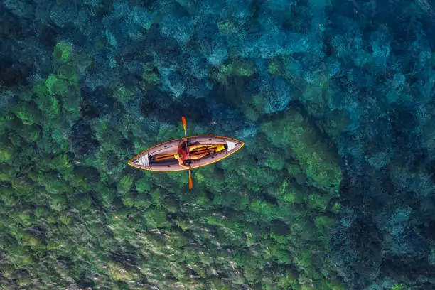High view of a man and his kayak in the clear, turquoise water of the Mediterranean sea