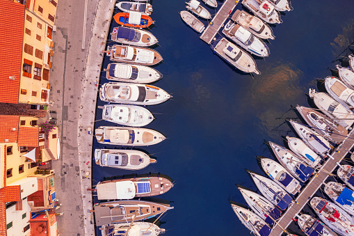 High view of yachts, sailing boats and inflatable boats moored at dock in the italian marina at dawn