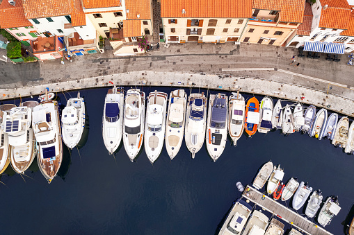 Top down view of a mediterranean island marina with boats moored at the pier