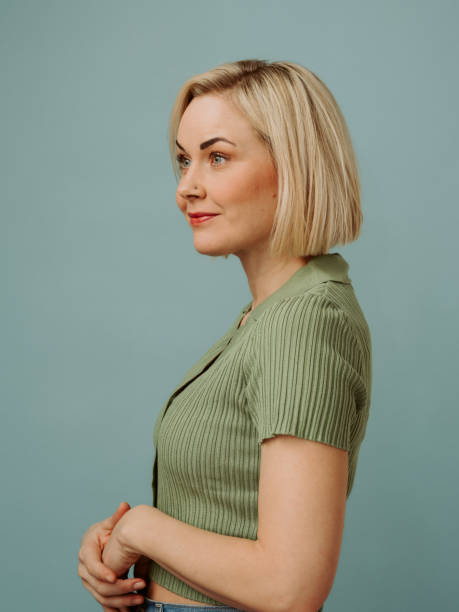 simple portrait of mid adult woman in her 40s with a short blonde bob in casual clothing - blue vertical color image photography imagens e fotografias de stock