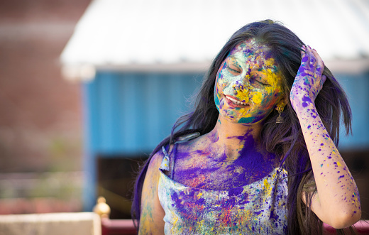 Close-up portrait of beautiful, happy Indian young woman enjoying the Holi festival of colors.