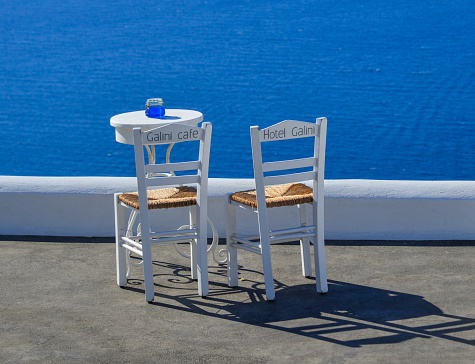 Two chairs with table on the terrace with sea view in Santorini Island, Greece.