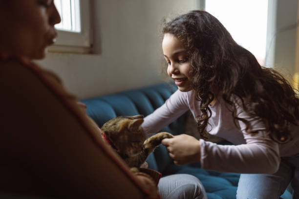 Mom and daughter playing with their cat